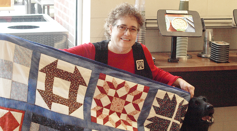 Laurie Leonard poses with her rendition of an underground railroad code quilt. Legend says quilts like these were put out to help lead escaped slaves to the North and freedom.