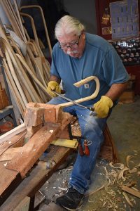 Alfred E. Jacques carves a lacrosse stick in his workshop on the Onondaga Nation. After 60 years he pulls the drawknife effortlessly, leaving hickory shavings at his feet. He makes approximately 200 highly sought after handmade wooden lacrosse sticks each year. 