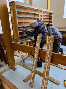 Hawley Arnold (left) and Stefan Merchant assemble the internal components within a wind chest, recently restored for the Basilica of Sacred Heart, Syracuse.